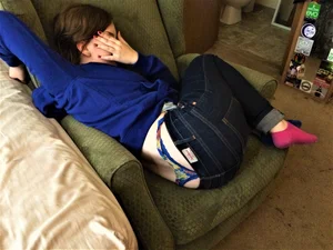 Girl Lying on the Couch Covering Her Face With Hand With Panties Sticking Out From Under Jeans