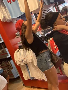 Bunch of girls in various outfits at a Cardinals baseball game