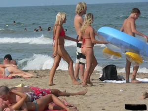 Sexy mom and daughter in red thongs at the beach