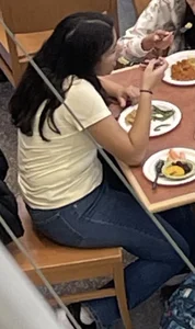 Chubby girl in tight jeans eating dinner