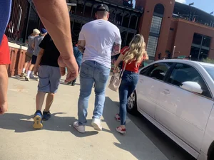 Bunch of girls in various outfits at a Cardinals baseball game