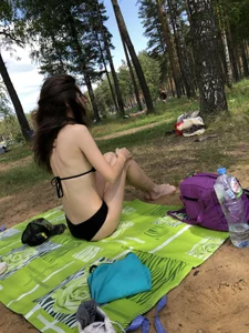 Pale Skinny Girl in Black Swimsuit Sitting on the Grass in a Park Creepshot