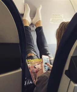 Girl in the Plane Seat with Her Feet in White Socks Leant Against the Wall