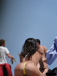 Topless lady on the beach in a gold thong with a nice ass