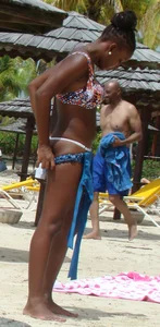 Sexy black babe in various bikinis on the beach while on vacation