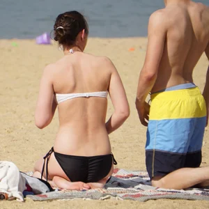 Sexy girl on the beach laying out and bending over in her bikini