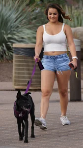 Sexy dog walker in shorts and tank top with friend in blue jeans
