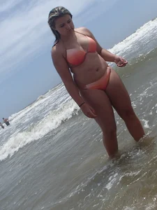 Thick beach girl with big boobs in a peach bikini