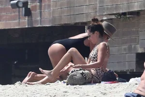 Ashley Tisdale in cheetah print swimsuit on the beach in Malibu