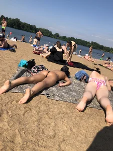 Gorgeous milf rubbing sun lotion in her skin at the beach, with a couple of her milf friends