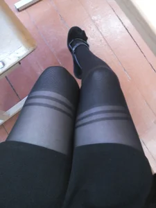 College Girl's Legs Closeup Selfie in a Skirt And Black Pantyhose Sitting at Her Desk in a Classroom