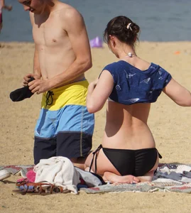 Sexy girl on the beach laying out and bending over in her bikini