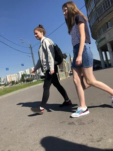 Cute Girl in a Short Denim Skirt Walking on a Street And Waiting on a Crosswalk Gallery