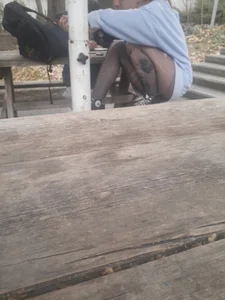College teen in ripped pantyhose sitting outside