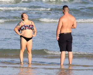 Thick flat assed tattooed lady on the beach in a bikini