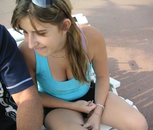 Girl leaning over to show off her nice tits while sitting on a bench
