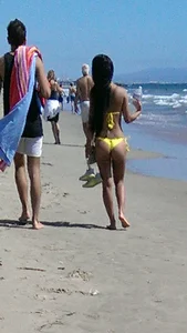 Beach babe with a nice ass and big tits in yellow thong bikini