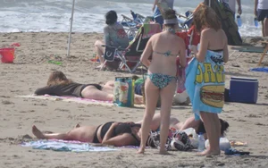 Bikini girls setting up for a day on the beach in their bikinis