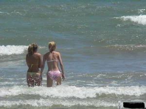Sexy blonde on the beach in a yellow thong bikini