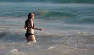 Cute bikini girl in the water in a black bikini