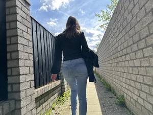 Sexy girl in tight blue jeans walking down a suburban street creepshots