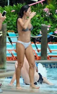 Sexy brunette lady with nice tits at the pool in a semi thong bikini