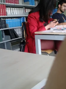 Sexy Candid Girl in Red Pantyhose And High-Heeled Shoes With a Mole on Her Thigh Sitting With Crossed Legs in the Library Creepshot