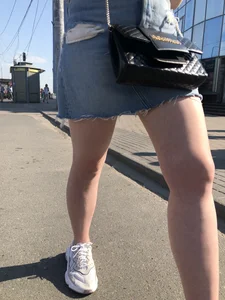 A very cute street candid girl wearing a denim fringed skirt passing by, great legs