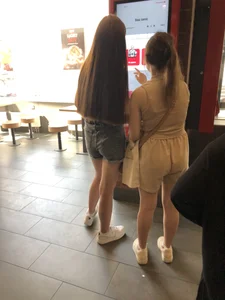 Couple of candid teens in shorts making order in fast food restaurand creepshots