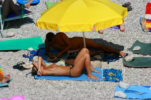 Nudist couple on the beach, girl has amazing tits and nice ass in a thong