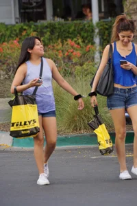 Sexy girl in denim shorts handcuffed to her friend outside