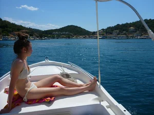 Skinny Girl in Swimsuit Sitting on Deck of a Yacht
