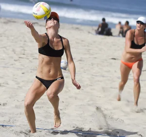 Hot girls playing beach volleyball in bikinis and shorts