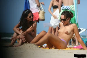 2 topless girls at the beach in thongs