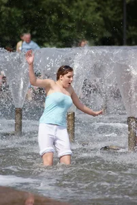 Big boobed girl in blue top with no bra playing in the water
