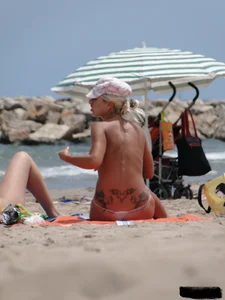 Tattooed blonde with big tits topless and in thong
