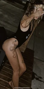 Non-candid girl with a snake tattoo coming out of the pool