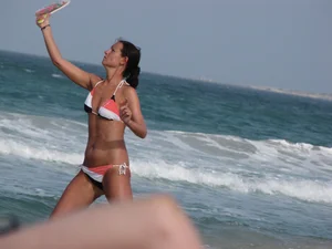 Skinny and sexy lady in a bikini playing on the beach