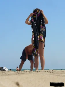 Topless beach milf looking sexy in a tiny g-string bikini