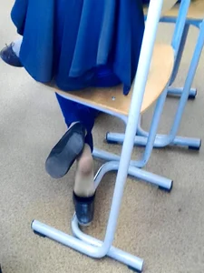 Teen college candid girl in skinny jeans dangling shoes under desk in class creepshots