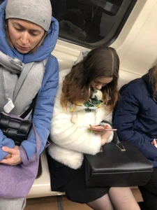 Very cute candid subway girl wearing black pantyhose sitting with crossed legs in the train
