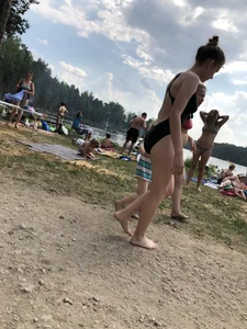 Cute Barefoot Girl in a Black Body Swimsuit Walking on a Road