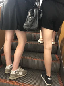 Two Teens in Skirts on a Subway Escalator Legs Closeups