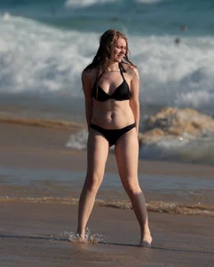 Cute bikini girl in the water in a black bikini