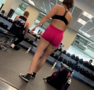 Bend over at gym in red shorts