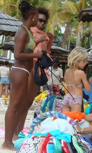 Sexy black babe in various bikinis on the beach while on vacation