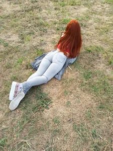Redhead with Amazingly Hot Booty and Legs Dressed in Tight Blue Jeans Lying on the Grass