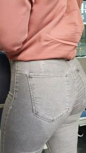 Blond girl in tight grey jeans waiting for the bus