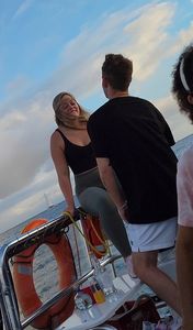 Blonde bending over on a boat in leggings