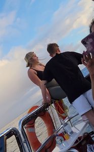 Blonde bending over on a boat in leggings
